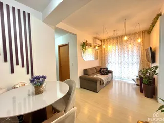 Sala de estar com sofá e mesa redonda em um apartamento.
