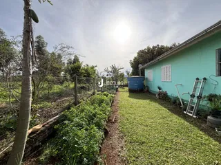 Vista da fachada de uma propriedade com jardim e cerca de madeira em Lajeado.