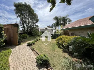 Vista da fachada de uma casa com jardim e calçada no exterior.