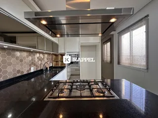 Cozinha moderna com bancada escura e exaustor de aço inoxidável.