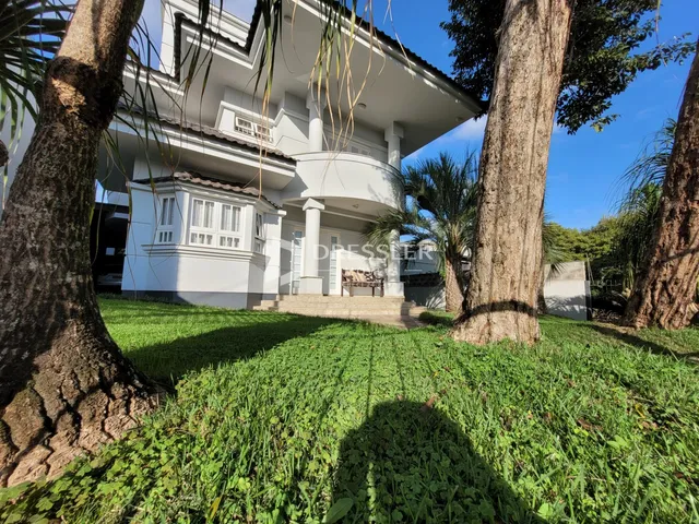 A fachada de uma casa branca em Lajeado, Brasil, cercada por gramado.