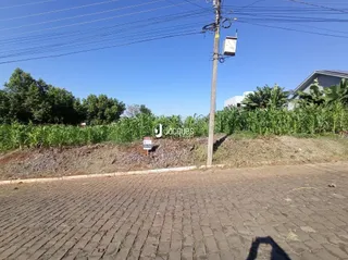 Vista externa de uma propriedade com poste e vegetação na frente.