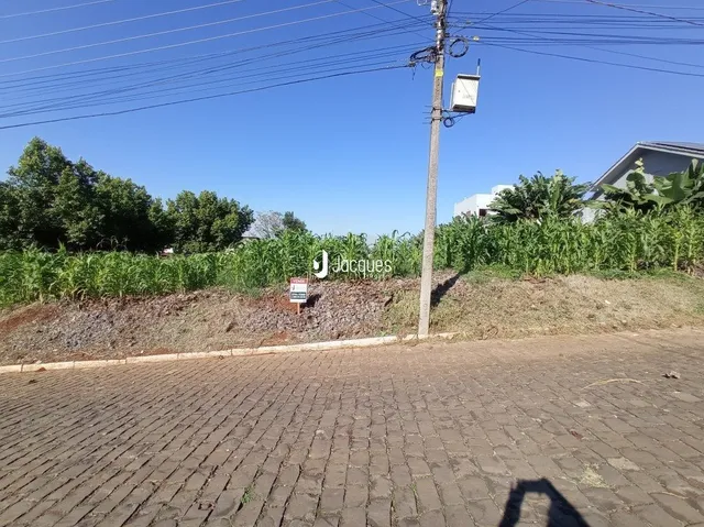 Vista externa de uma propriedade com poste e vegetação na frente.