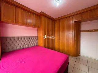 Quarto com armários de madeira e cama rosa em um imóvel em Lajeado.