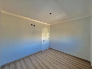 Vista interna de um cômodo com piso de madeira.