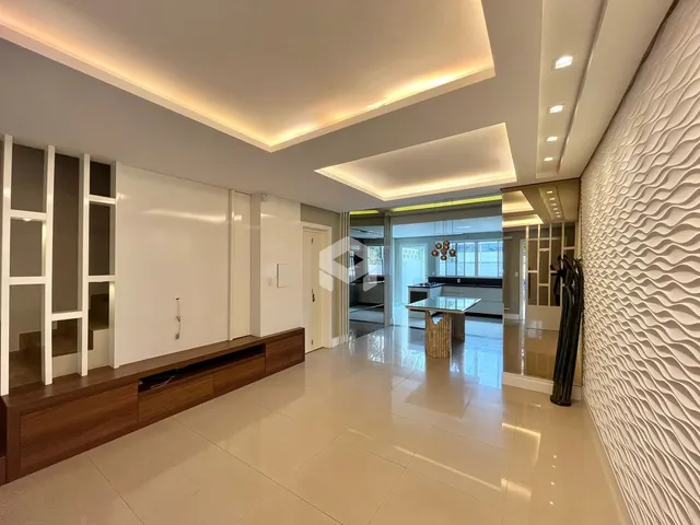 Sala de estar moderna com piso claro e iluminação embutida.