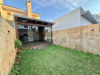 Fachada de imóvel com porta de vidro e jardim gramado.