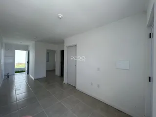 Hall de entrada com piso de cerâmica claro e paredes brancas.