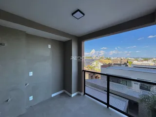 Vista interna de um ambiente com paredes cinzas e acesso a uma varanda.