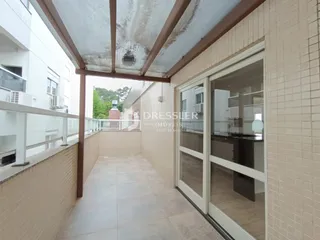 Corredor externo com piso de cerâmica e portas de vidro de uma residência em Lajeado.