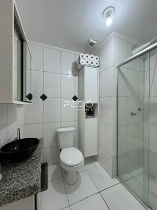 Foto de um banheiro com azulejos brancos e box de vidro.