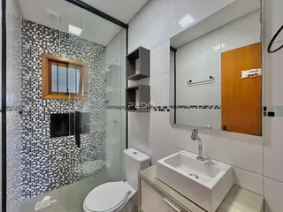 Foto de um banheiro com revestimento de azulejos pretos e brancos.