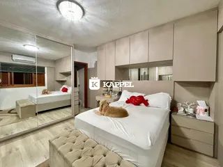 Quarto com cama grande e armários em um apartamento.