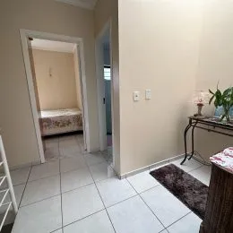 Hall de entrada com piso de cerâmica e parede clara.