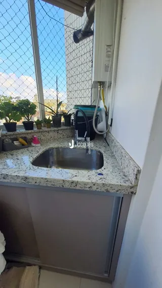 Vista da bancada da cozinha com pia e janela em Lajeado.
