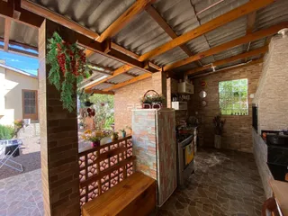 Interior de uma área comum com paredes de tijolo e vigas de madeira expostas.