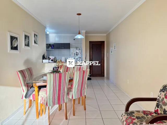 Uma sala de jantar com mesa e cadeiras listradas em um apartamento.