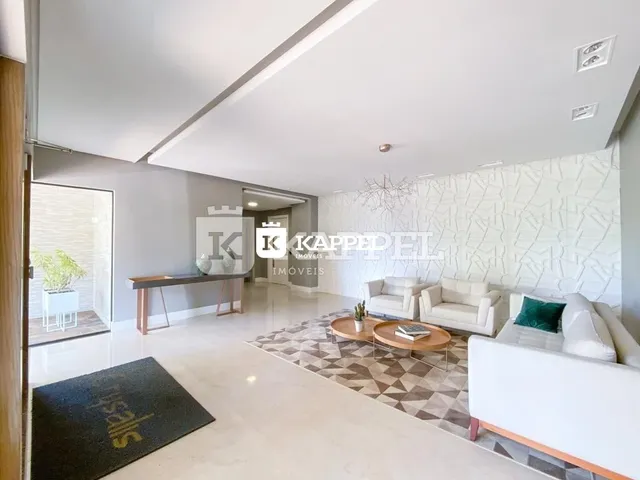 Sala de estar com piso claro e mesa de madeira no ambiente.
