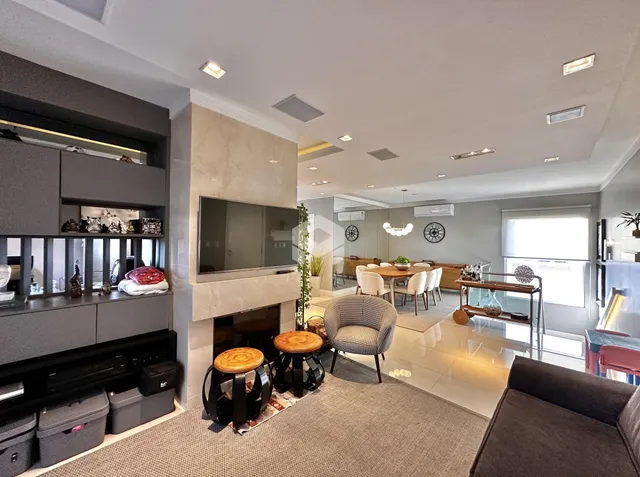Sala de estar moderna com lareira e área de jantar em apartamento.