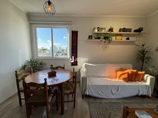 Sala de estar com mesa de jantar e janela de vista para a cidade.