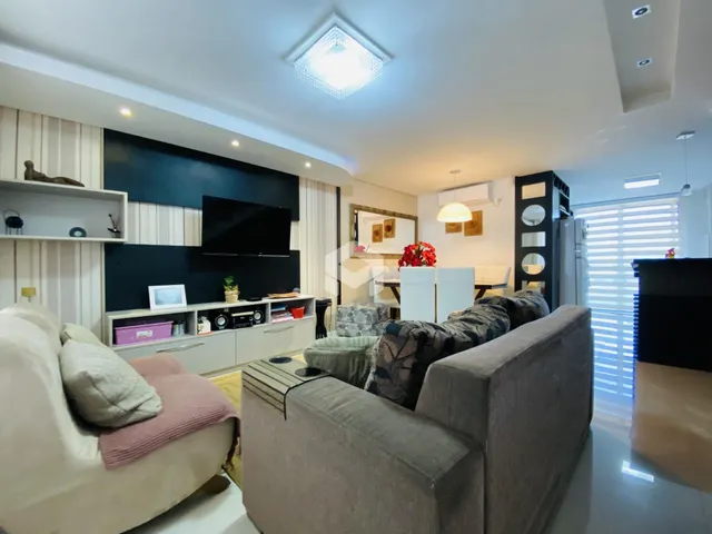 Sala de estar moderna com sofá e painel de TV.