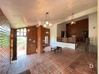 Sala de estar com piso de cerâmica e paredes de tijolo aparente.