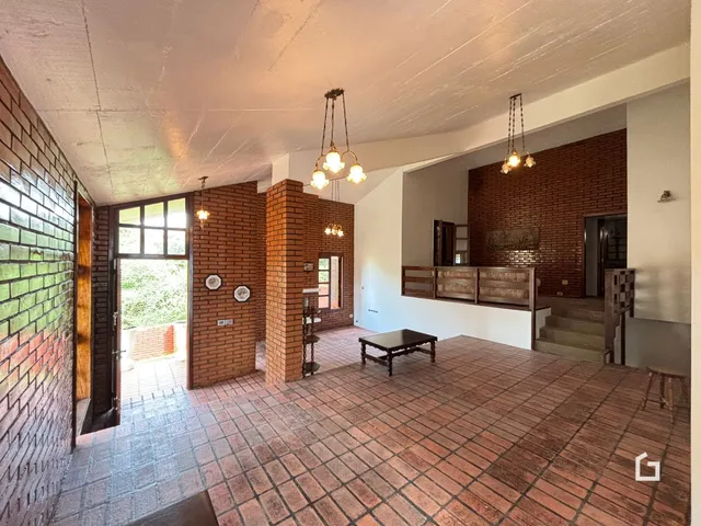 Sala de estar com piso de cerâmica e paredes de tijolo aparente.