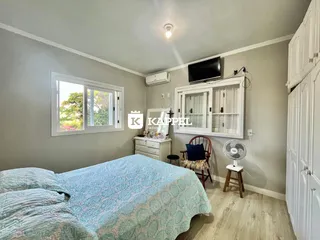 Um quarto com cama e janela mostrando a vista externa.