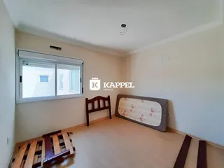Quarto com cama de madeira e piso de madeira clara.