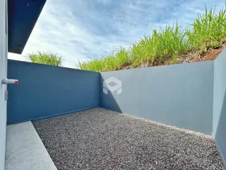 Vista externa de um muro e jardim com vegetação alta.