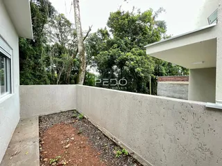 Vista da lateral da propriedade com muro e área externa.