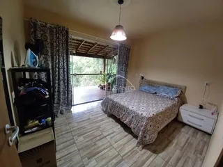 Quarto com cama e cortinas escuras, com acesso a uma área externa.