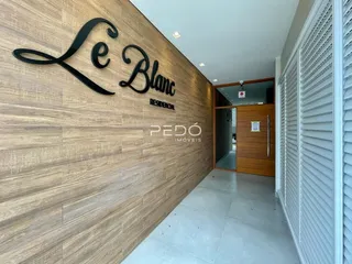 Hall da entrada de uma residência com parede de destaque em madeira.