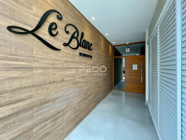Hall da entrada de uma residência com parede de destaque em madeira.