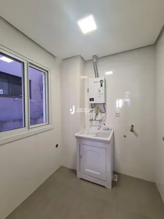 Vista de um banheiro com pia branca e janela em uma residência.