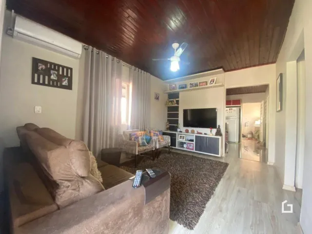 Sala de estar com sofá e teto de madeira.