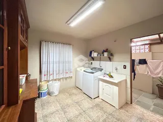 Interior da cozinha com armários de madeira e piso de cerâmica.