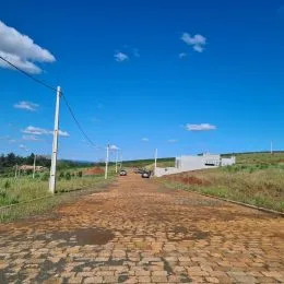 Vista de um caminho de terra em uma área aberta sob um céu azul.