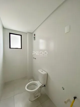 Hall de entrada com vaso sanitário branco.