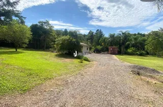 Vista externa da propriedade com gramado e acesso de cascalho.