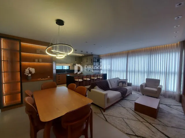 Sala de estar e jantar de um apartamento moderno com grandes janelas.