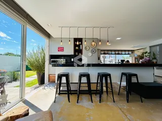 Cozinha moderna com bancada escura e portas de vidro que dão acesso ao exterior.