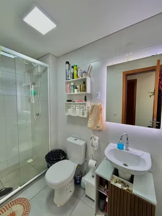 Foto de um banheiro com piso cerâmico e box de vidro.