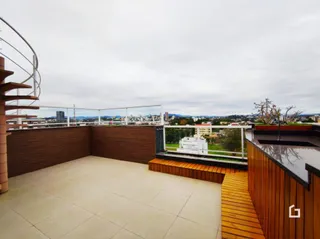 Vista da área externa com piso de madeira e grade de segurança.