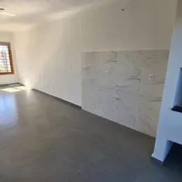 Foto de um ambiente interno com piso de concreto polido e parede de revestimento de mármore claro.