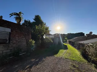 Exterior da propriedade mostrando um muro de tijolos e um caminho de terra.