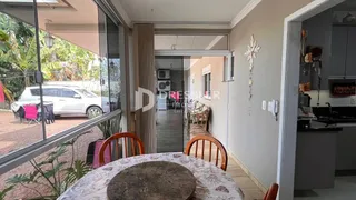 Vista de uma sala de jantar com vista para o jardim através de portas de vidro.
