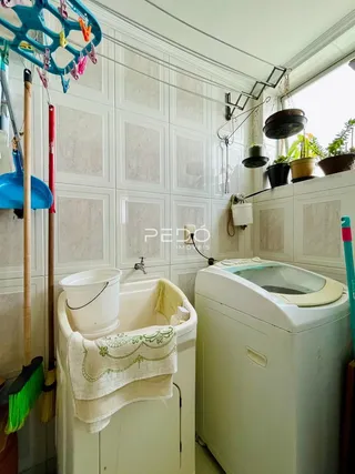 Foto de um ambiente interno com paredes brancas e uma máquina de lavar roupa.