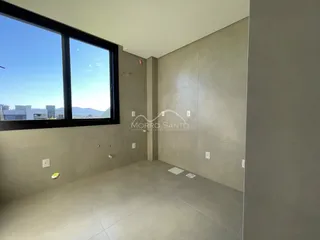 Foto de um ambiente interno com grande janela mostrando a vista da cidade.