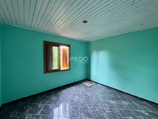 Quarto com paredes verde-água e piso de mármore escuro.